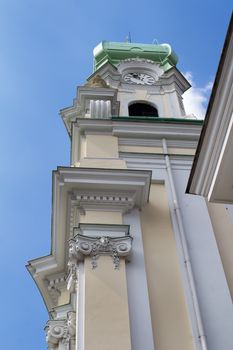 View on the facade of St. Elizabeth church. Baroque details, tower with clock and green roof. Blue sky with a small cloud.