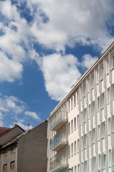 Detail of a modern building. Contrast bright blue sky with white clouds.