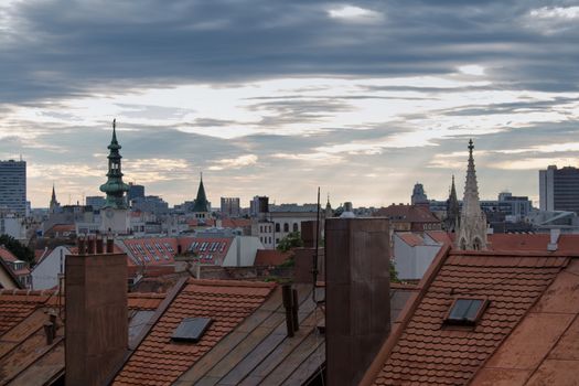 Early morning view on the roofs and towers of the old city in Bratislava. Cloudy rainy sky with a little sunlight.