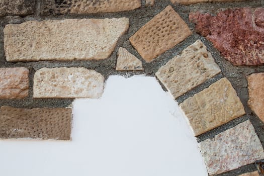 Wall of a building with decoration made of colorful bricks. From beige, orange to red color.