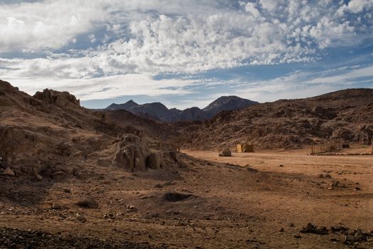 Landscape in the desert in Egypt. Rocky hills. Blue sky with many white clouds.