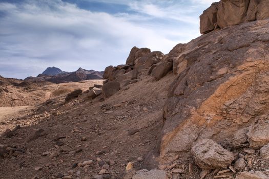 Landscape in the desert in Egypt. Rocky hills. Blue sky with many white clouds.