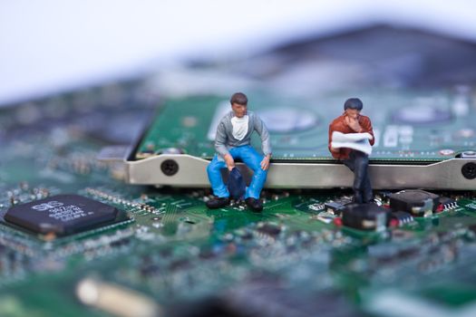 Macro picture of computer electronics with people sitting