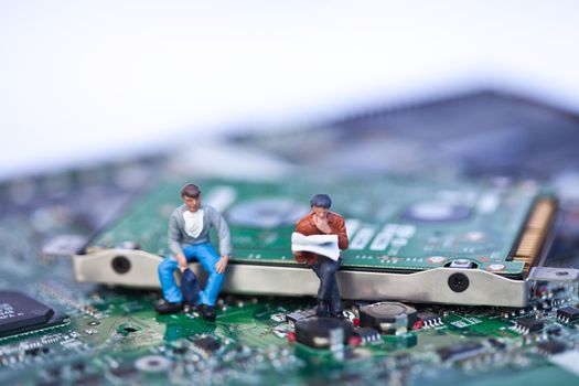 Macro picture of computer electronics with people sitting