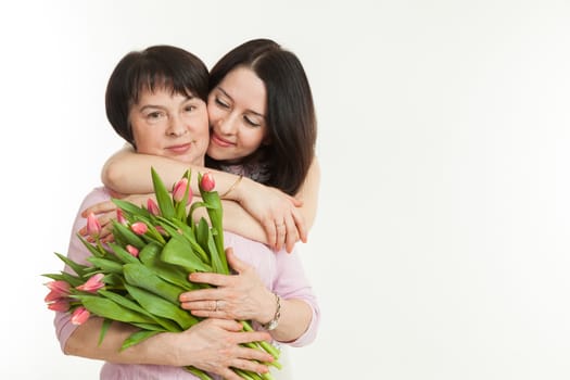 the woman presented a bouquet of flowers for mother and embraces her