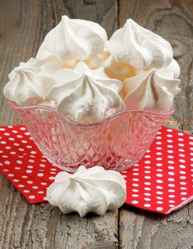 Dessert Vase Full of White Meringue Cookies on Red Polka Dot Napkin closeup on Rustic Wooden background