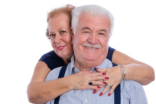 Pair of older husband and wife in loving embrace with expression of a long life together over white background