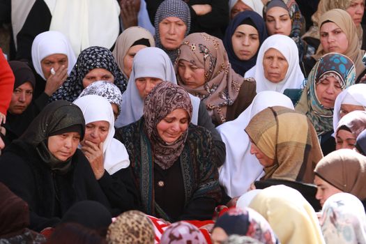 WEST BANK, Al-Ubeidiya:  Mourners stand next to the body of a dead Palestinian man identified as Naim Ahmad Yousif Safi, 17,  during his funeral ceremony in Al-Ubeidiya, east of Bethlehem, on February 15, 2016.Safi, 17, tried to stab Israeli border police at a checkpoint between Jerusalem and Bethlehem in the West Bank before being shot dead on February 14, 2016, Israeli authorities said.  