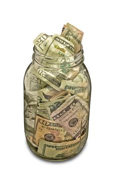 Clear glass money jar full of cash on a white background.