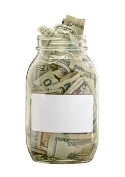 Clear glass money jar full of cash on a white background.