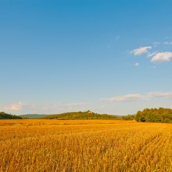 Farmhouse on the Hill in the Middle of the Field After Harvest