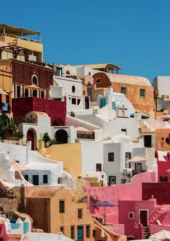 Colorful houses on a cliff by the sea on a sunny day on Oia Santorini island