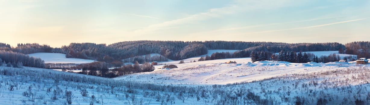 Panorama of Winter hills. Frozen meadow. Frost on trees 