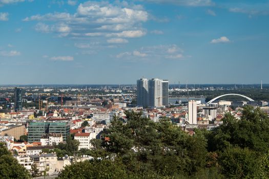 View on the capital of Slovakia, Bratislava. Center of the city, with skyscrapers, bridge and factory in the background. Blue sky with white clouds.