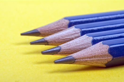 Four pronged pencils on yellow background