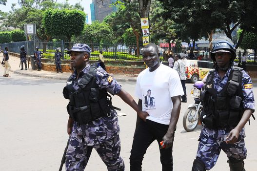 UGANDA, Kampala: A police officer arrests a supporter of Forum for Democratic Change (FDC) presidential candidate Kizza Besigye in Kampala on February 15, 2016 during clashes between police and supporters.Violence erupted as the opposition candidate was arrested twice on his way to several rallies by the police.