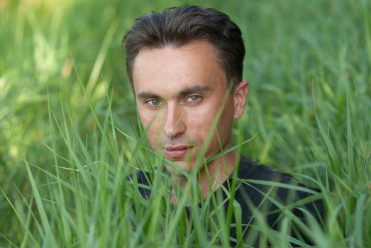 Man's portrait in the green grass background