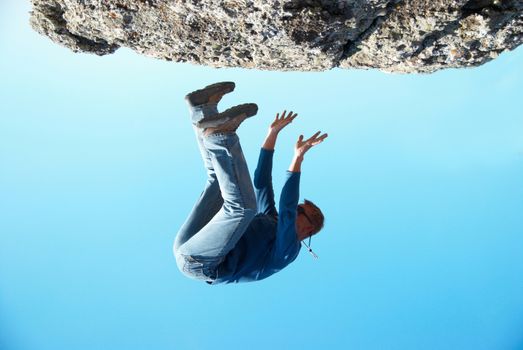 Falling down man from the rock with blue background