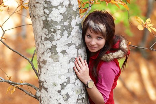 Beautiful girl's portrait near tree in the autumn park