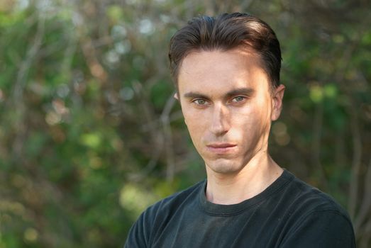 Man's portrait in the soft forest background