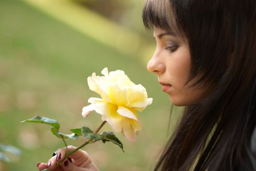 Beautiful girl with yellow rose, soft background