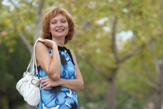 Young woman walking in autumn park soft background