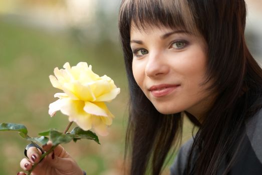 Beautiful girl with yellow rose, soft background