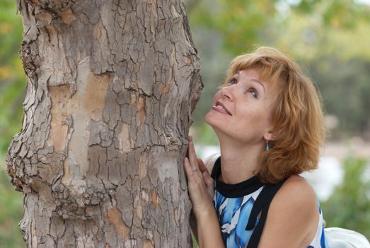 Beautiful woman near tree, with soft background