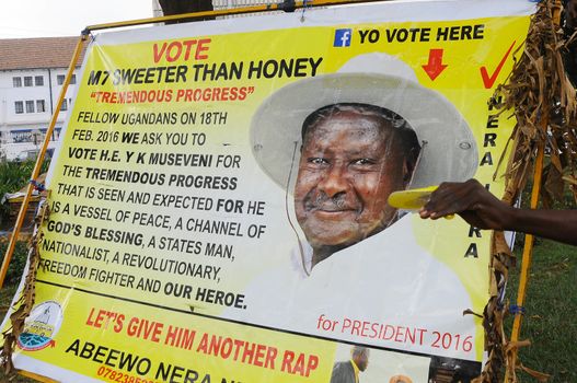 UGANDA, Kampala: A Supporter of Uganda's incumbent president Yoweri Museveni is seen playing with his portrait in Kampala, Uganda, on February 15, 2016. Uganda entered the final day of campaigning today in elections that will likely secure another term for President Yoweri Museveni, already the longest-serving leader in the region. 