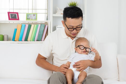 Asian family lifestyle at home. Father and baby wearing nerd glasses. Infant eyes care concept.