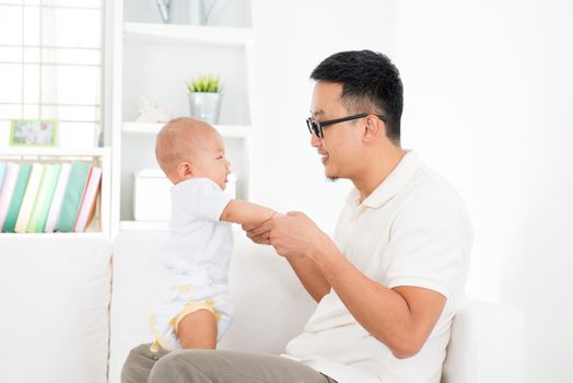 Father and baby boy playing at home. Southeast Asian family lifestyle indoors.
