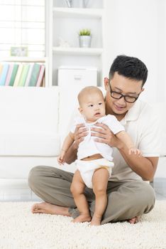 Asian father and baby boy playing at home. Family lifestyle indoors.