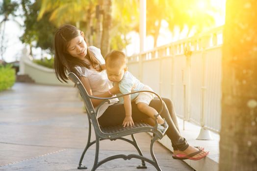 Mother and son having fun at outdoor in sunset during vacation.