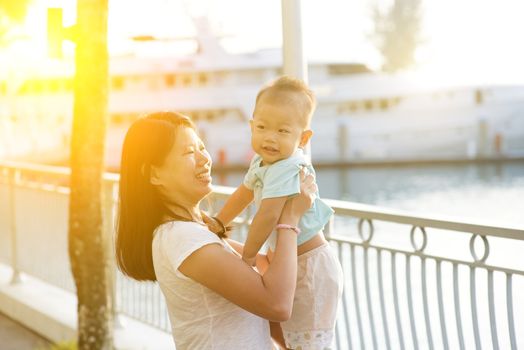 Asian mother and son having fun time at outdoor in sunset during vacations.