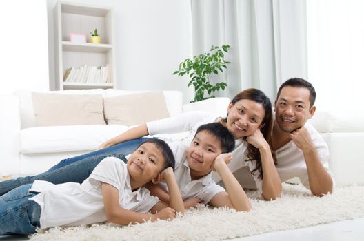 Asian family lying on the floor and smiling