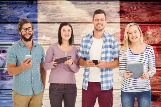 Portrait of smiling business people using electronic gadgets  against composite image of usa national flag