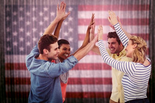 Happy creative team giving high fives to each other against composite image of usa national flag
