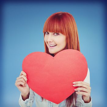 Attractive hipster woman behind a red heart against blue sky