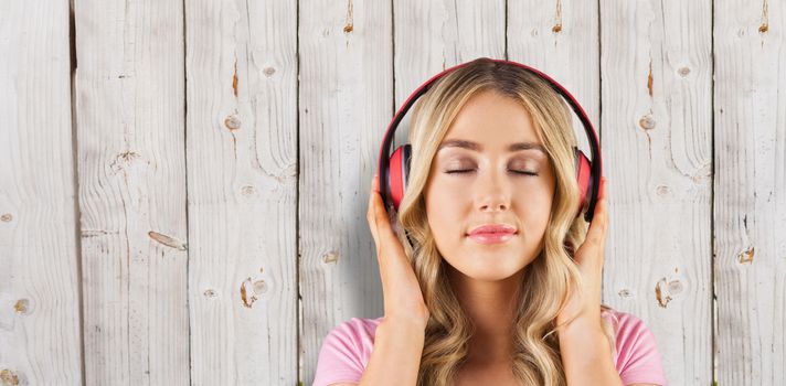 Close up of a woman listening to music  against wooden background