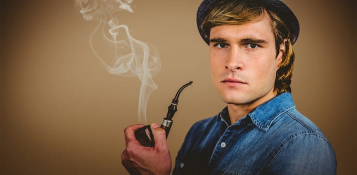 Serious hipster holding pipe against grey background with vignette
