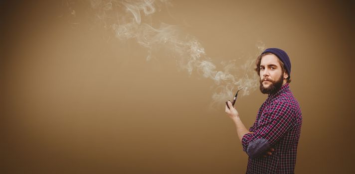 Side view of hipster holding smoking pipe against grey background with vignette
