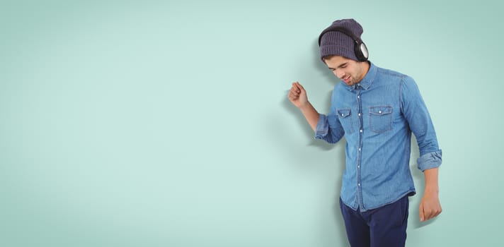 Hipster wearing headphones enjoying music against blue vignette background