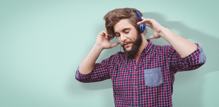 Hipster wearing headphones against blue vignette background