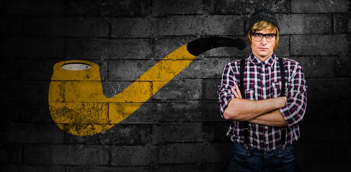 Serious blond hipster crossing arms against texture of bricks wall