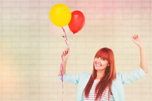 Smiling hipster woman holding balloons against textured background