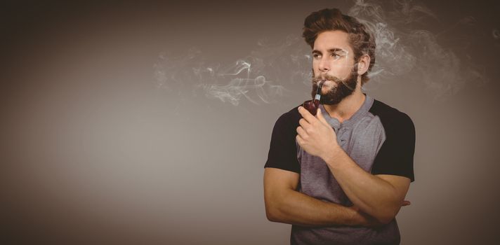 Confident hipster smoking pipe against grey vignette