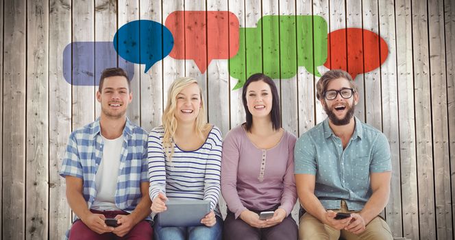 Portrait of smiling business people holding electronic gadgets  against wooden planks background