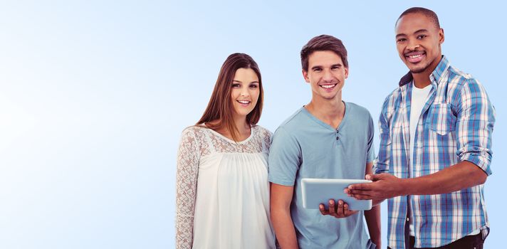 Young creative team looking at tablet against blue background