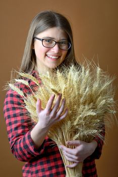 girl hold in hand bunch of wheat stalks shoot in studio
