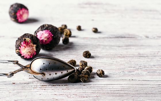 Several types of leaf tea light on a bright wooden background.